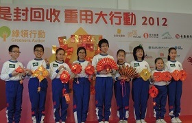 A group of primary students are holding various pendants making use of recycled lai see packets in the ceremony.